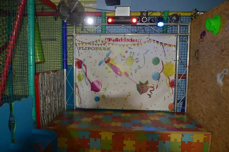 Escenario de cumpleaños de FlipoPark con photocall de globos, tarima de puzle y equipo de luces