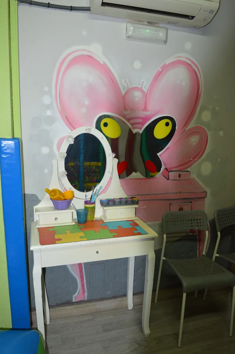 Rincón de manualidades con mesa de pintura, puzles y espejo para los más pequeños